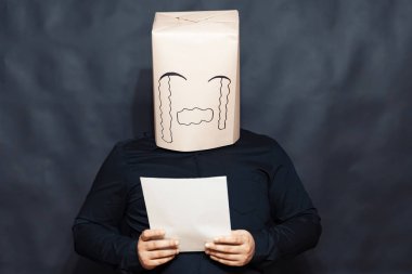 Duygular kavramı. Bir adam bir mektup okuyor. Yüz, kızgınlık ve üzücü bir ifade üzerinde. Haddelenmiş gözyaşları.