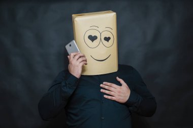 Duygular kavramı. Bir adam bir iletiye cep telefonundan dinler. Aşık gözleri görünüyor. Yüzünü gülümseme ve mutluluk.