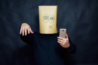 Duygu kavramı. Bir adam bir cep telefonu görünüyor. Sol el fiyatına bir işareti ile ortaya çıkar. Yüzünde sakin bir ifadesidir.