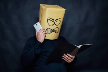 Duygu kavramı. Bir adam, bir elinde bir defter tutar. Öte yandan bir cep telefonu tutuyor. Onun yüzünde yoğun irritasyon ve sinirlilik denilir.