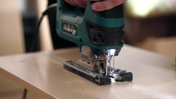 Work with a manual electric fret saw. Making a direct cut in a wooden plate. — Stock Video