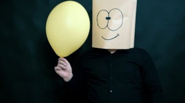 Duygu kavramı. Bir adam bir balon elinde tutuyor. Sol başparmak işaret ediyor. Yüzünü gülümseme ve ifade kutlama.