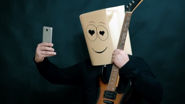 Emocja koncepcja. Człowiek ma sobie selfie z gitarą w jego ramionach. Patrząc oczami kochanków. Na twarzy uśmiech i szczęście. — Wideo stockowe