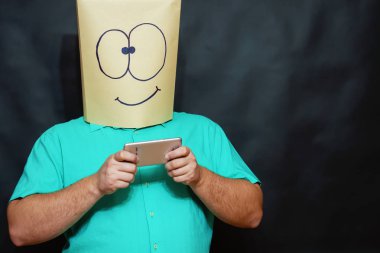 Duygu kavramı. Bir adam bir akıllı telefon elinde tutar. Bir gülümseme ile mesajı okur.