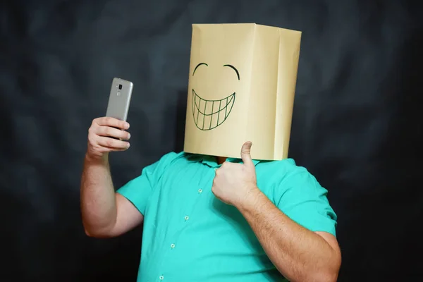 Emotionales Konzept. Ein Mann macht ein Selfie mit seinem Handy und zeigt mit der Hand Zeichen von Sieg und Erfolg. auf dem Gesicht ist ein Lächeln und ein Ausdruck der Freude. — Stockfoto