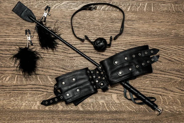 Seks oyuncakları ve Bdsm nesne üzerinde ahşap arka plan belirleme.