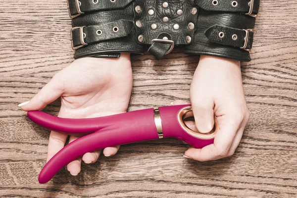 Seks oyun. Elleri kelepçeli. Ahşap arka plan üzerinde yapay penis