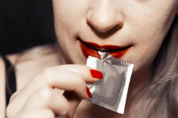 Concepto de sexo seguro. Condón de unboxing chica. Los labios rojos — Foto de Stock