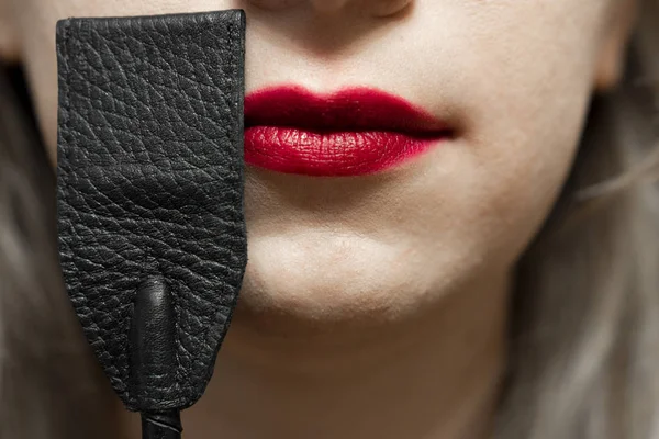 Плети рядом с красными губами. Концепция секса и фетиша bdsm — стоковое фото