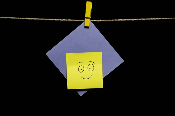 Espaço para cópia. Adesivo com um emoticon em papel azul anexado a um pano de corda. Emoções. Conceito feliz e atitude positiva . — Fotografia de Stock