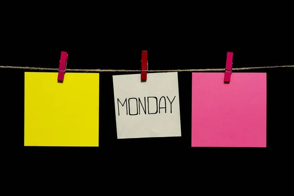 Kopírovat prostoru. V pondělí. Poznámka je napsán na bílém štítku. Různobarevné listy papíru připojené k provazu clothespins. — Stock fotografie