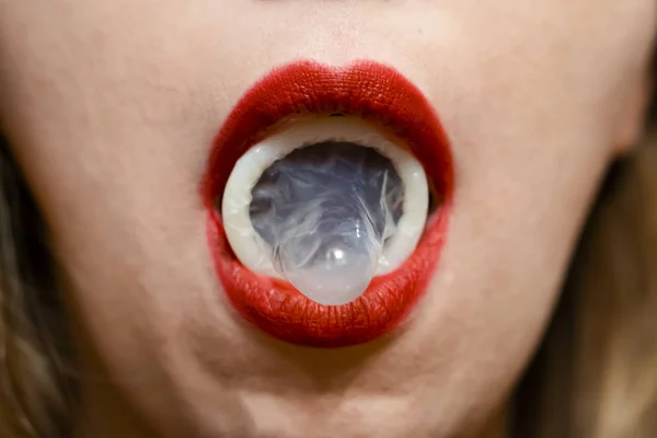 Презерватив на женском языке. Красные губы. Сексуальная концепция — стоковое фото
