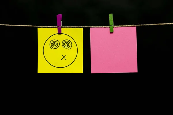 Copiar espacio. Dos pegatinas. En el amarillo de una cara sonriente una expresión de aturdido. Pegatinas se adjuntan a la cuerda con pinzas de ropa . —  Fotos de Stock
