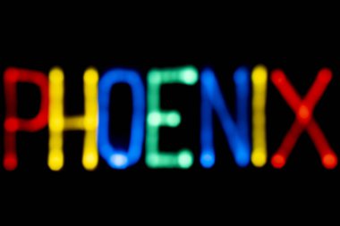 Işık boyama. Şehir adı. Phoenix. Mavi, sarı, yeşil ve kırmızı renkler. Siyah arka plan.
