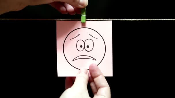 Emoce. Na tváři takový výraz zklamání. List je připojen ručně s clothespin na laně. — Stock video