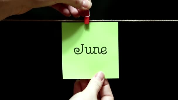 Yılın ayı. Yaz. Sayfa kitabe Haziran. Sayfayı el ile bir clothespin halata ile bağlı olduğu. — Stok video