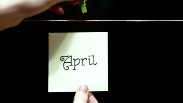Ändring av månader per år. April maj. Våren. Lakanen byts manuellt med en klädnypa på repet. — Stockvideo