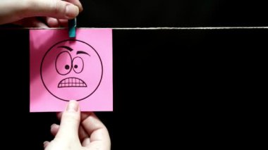 İki çıkartmaları. Duygular. Öfke bir yüz ifadesi ile pembe etiket. Bir sevgi ifadesi yüzündeki pembe sayfasında.