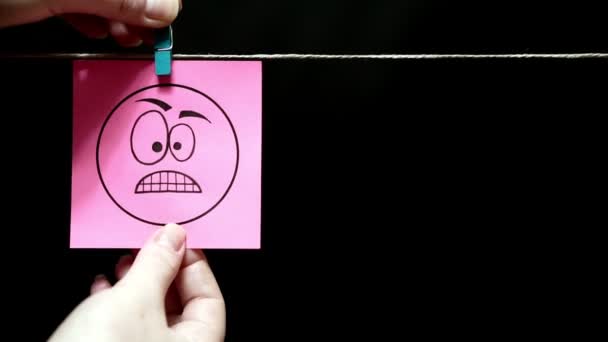 Deux autocollants. Des émotions. Sticker rose avec une expression faciale de colère. Sur la page bleue sur le visage une expression de déception et de tristesse . — Video