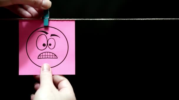 Deux autocollants. Des émotions. Sticker rose avec une expression faciale de colère. Sur la face droite de la feuille avec sourire et bonne nature . — Video