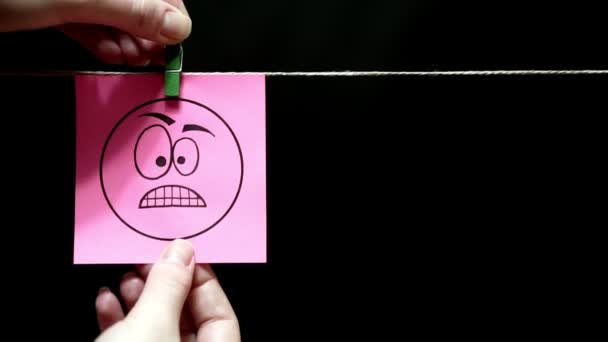 Две наклейки. Эмоции. Розовая наклейка с выражением гнева на лице. На правой желтой странице находится символ процента . — стоковое видео