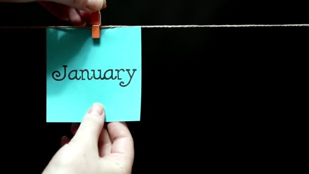 Two multicolored stickers. On left blue a sheet inscription January. On the right white a sheet an expression of festive mood. — Stock Video