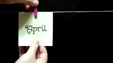 İki çıkartmaları. Duygu. Üzerinde bir levha yazıt Nisan beyaz yaptı. Para yüzü ifade aşk şu yeşil kağıda üzerinde.