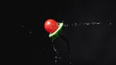 Çatalda domates ve salatalık. Dondurucu hareketler su sıçratır