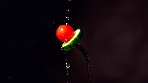 Tomate et concombre sur une fourchette. Congeler mouvement éclaboussures d'eau — Photo