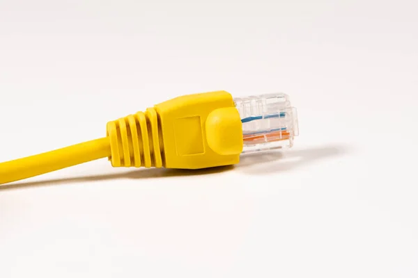 Câble réseau jaune avec fiche RJ45 moulée isolée sur fond blanc. — Photo