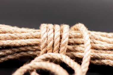 Karanlık bir arka planda bir yığın jüt halat. Kısmen açılmamış.