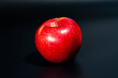 Koyu arkaplanda taze kırmızı elma. Meyvenin parlak doğal rengi. 