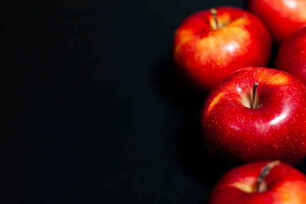 Çerçevenin sağ tarafındaki koyu bir zeminde taze kırmızı elmalar.. — Stok fotoğraf