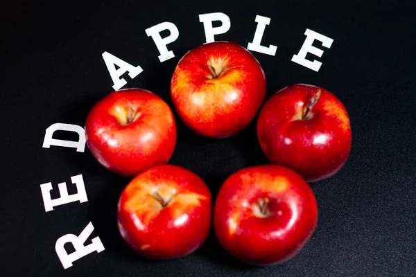 Świeże czerwone jabłka na ciemnym tle w środku ramki. — Zdjęcie stockowe