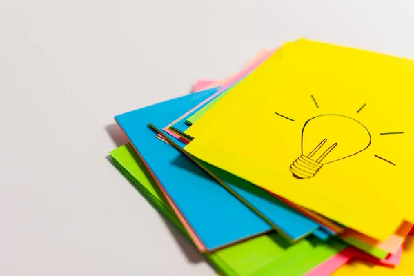 Stacks of paper of different colors are arranged in a column on a white surface. Concept idea — Stock Photo, Image