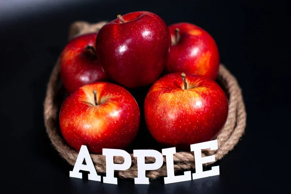 화면 중앙에 신선 한 빨간 사과 한 무더기가 있습니다. 과일들을 운반하는 밧줄과. — 스톡 사진