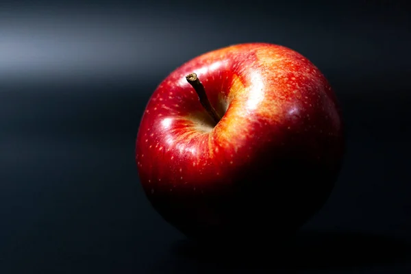 Suculento maçã vermelha em um fundo escuro. Cor natural brilhante de fruto de Apple. — Fotografia de Stock