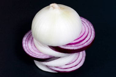 Koyu arkaplanda dilimlenmiş beyaz ve kırmızı soğanlar..