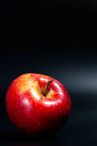 Karanlık bir arka planda lezzetli kırmızı elma. Çerçevenin üstü reklam için ücretsiz.. — Stok fotoğraf