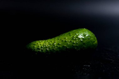 Ekranın ortasında koyu bir arkaplanda salatalık.