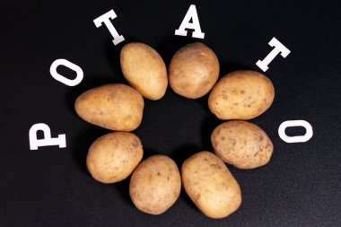 Ekranın ortasında, karanlık bir yüzey üzerinde, daire şeklinde bir patates grubu var..