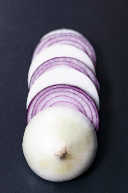 Dilimlenmiş beyaz ve kırmızı soğan. Objektife doğru bir çizgi şeklinde konum.