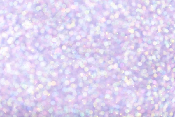 Blurred lilac background with circle sparkling lights. Shiny brilliant glittery bokeh of christmas garland. Light violet multicolored backdrop