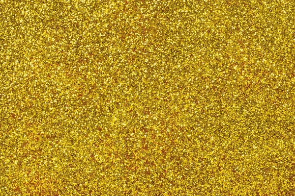 Golden sparkling background from small sequins, closeup. Brilliant shiny backdrop from textile. Shimmer yellow paper