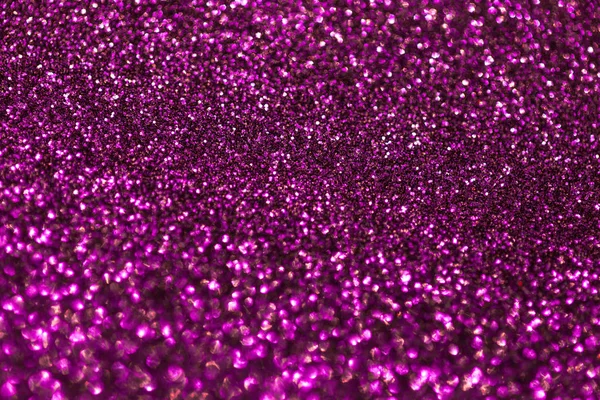 Dark purple sparkling background from small sequins, closeup. Brilliant backdrop.