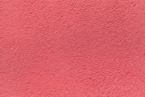 Alte hellrote Wand mit schäbigem, unebenem Putz überzogen. Textur der rosa Steinoberfläche. — Stockfoto