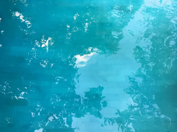 Fundo turquesa de água da piscina com reflexo de palmeiras na superfície . — Fotografia de Stock