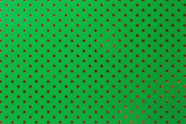 Altın yıldız desenli metal folyo kağıttan koyu yeşil arka plan.