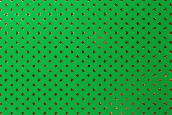 Fundo verde escuro de papel de folha de metal com um padrão de estrelas douradas . — Fotografia de Stock