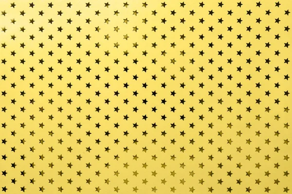 黄色背景从金属箔纸与金色的星星图案 — 图库照片